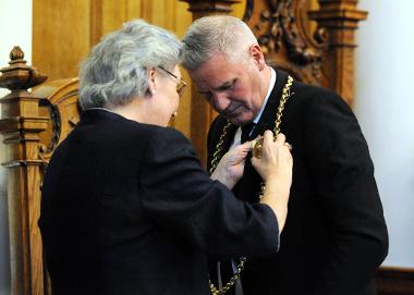 Councillor Pat Hay presents new Mayor, Councillor John McCabe with his chains of office.